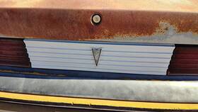 Pontiac 16501291 85-87 Sunbird License Plate Trim Surround Panel 2dr Tail Trunk Finish